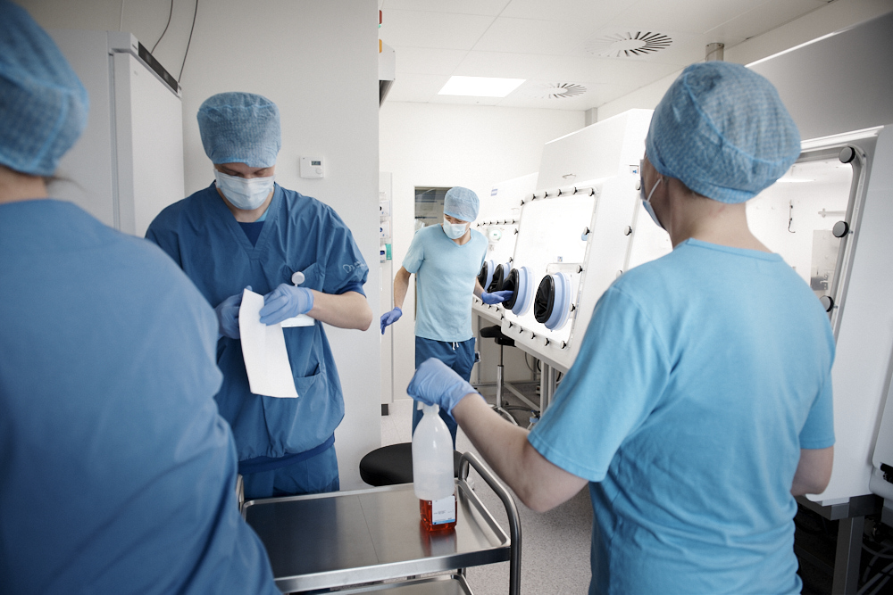 RW-210520-SDU-Clinical Research-188 Laboratory personnel in a GMP-grade cleanroom environment using glove box isolators for stem cell culture. PL BioScience corporate image illustrating the safe manufacturing of ATMPs and the use of European-origin hPL (human platelet lysate).